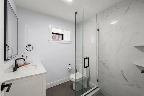a bathroom with a sink a toilet and a mirror