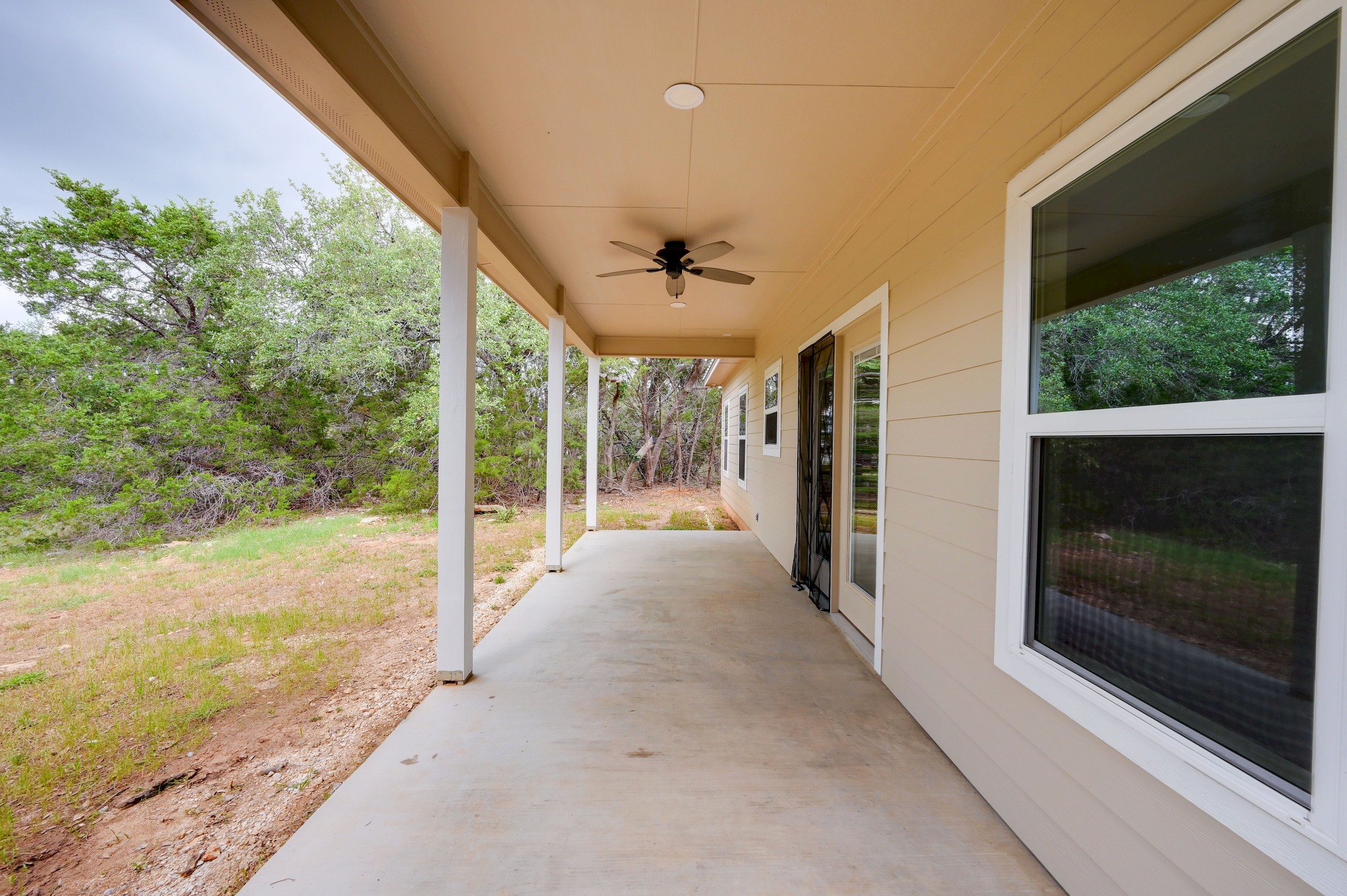 231 North Rainbow Ranch Road Wimberley, TX 78676 - Photo 30 of 40 A spacious covered patio offers a refreshing outdoor retreat, complemented by a serene natural landscape.