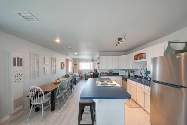 a kitchen with a refrigerator a stove a dining table and chairs