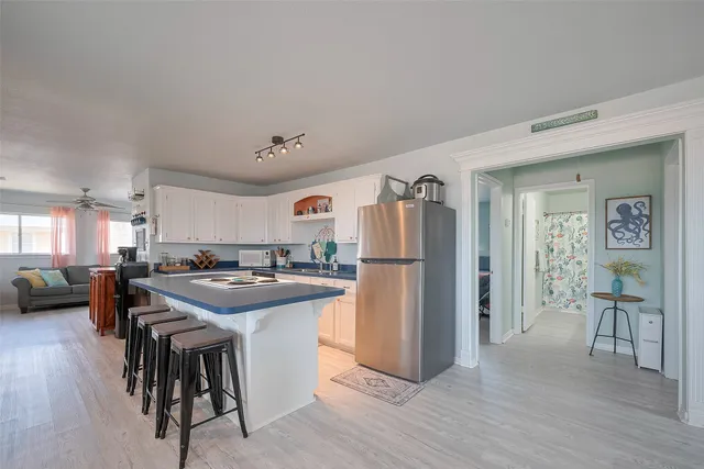 a kitchen with a refrigerator a stove a dining table and chairs