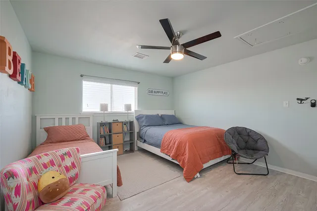 a bedroom with two beds and windows