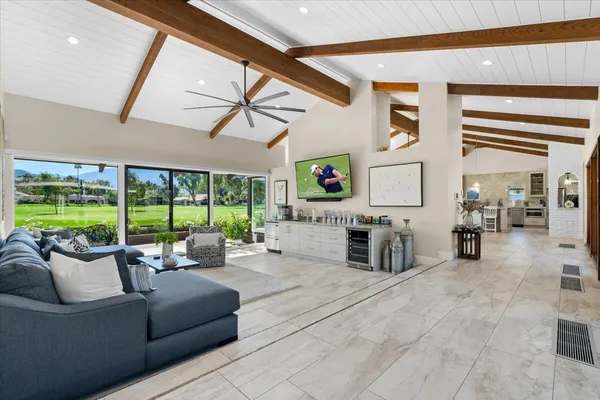 a living room with furniture and a floor to ceiling window