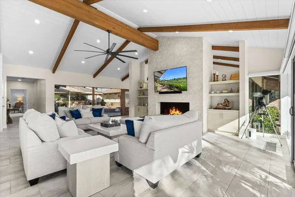 a living room with patio furniture and a large window