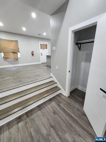 a view of a hallway with wooden floor and closet