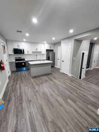 a large kitchen with stainless steel appliances wooden floors and wooden cabinets