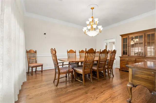 a view of a dining room with furniture a chandelier and wooden floor