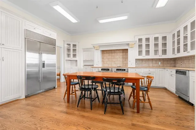 a dining area with stainless steel appliances kitchen island granite countertop a dining table chairs and granite counter tops