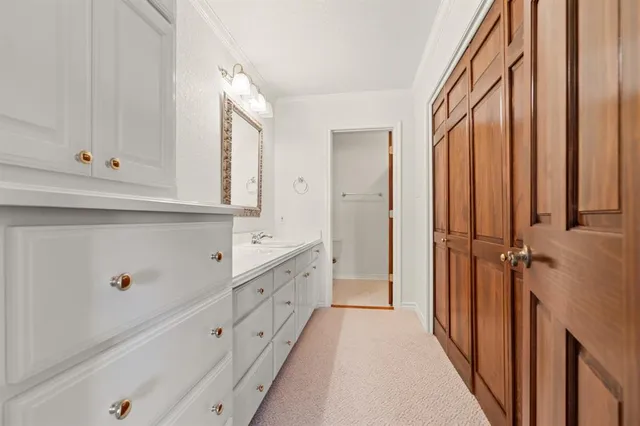 a bathroom with granite countertop white cabinets and sink