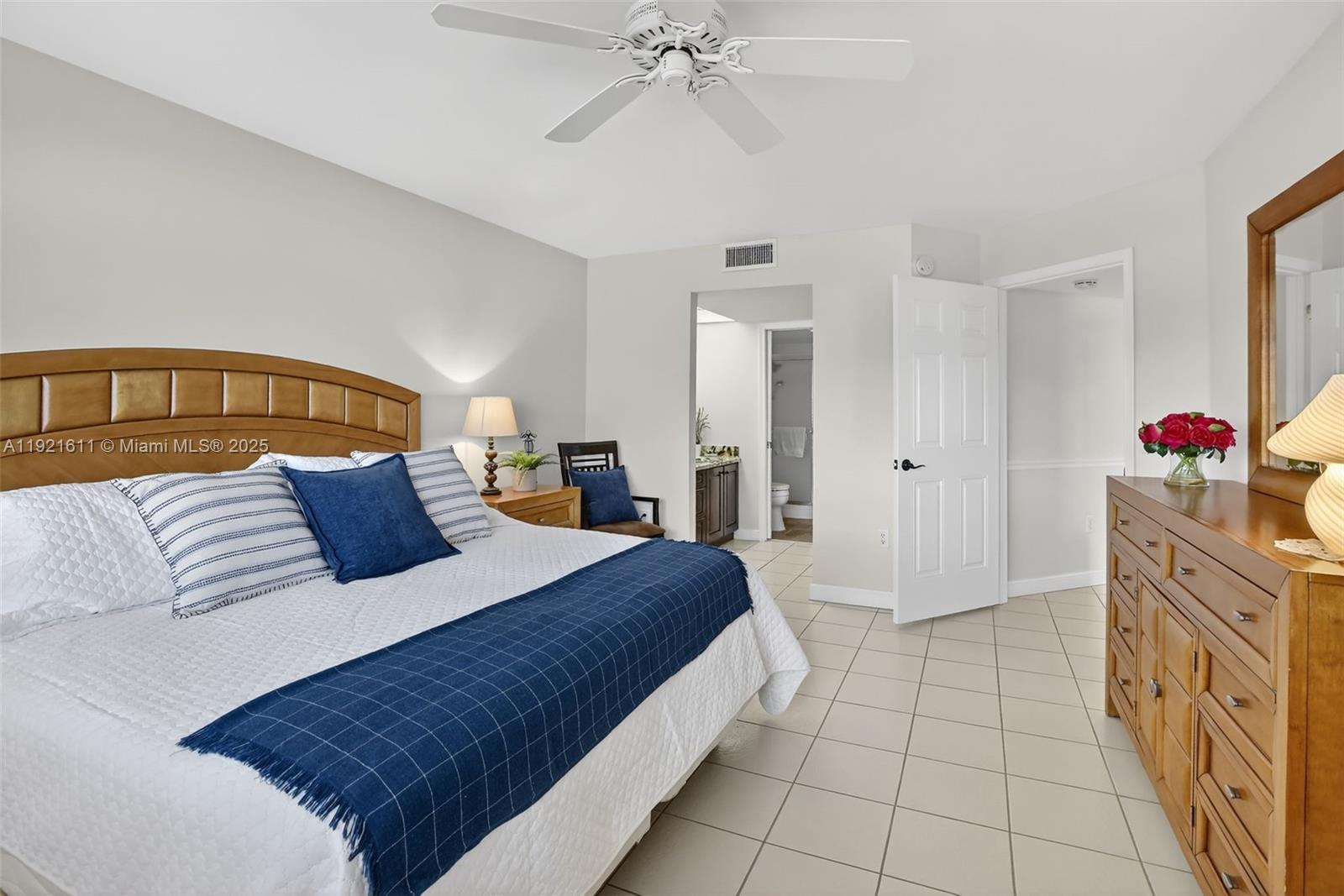 13705 Southwest 12th Street, Unit 103B Pembroke Pines, FL 33027 - Photo 21 of 59 a spacious bedroom with a bed and a chandelier