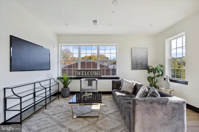 a living room with furniture a window and a flat screen tv