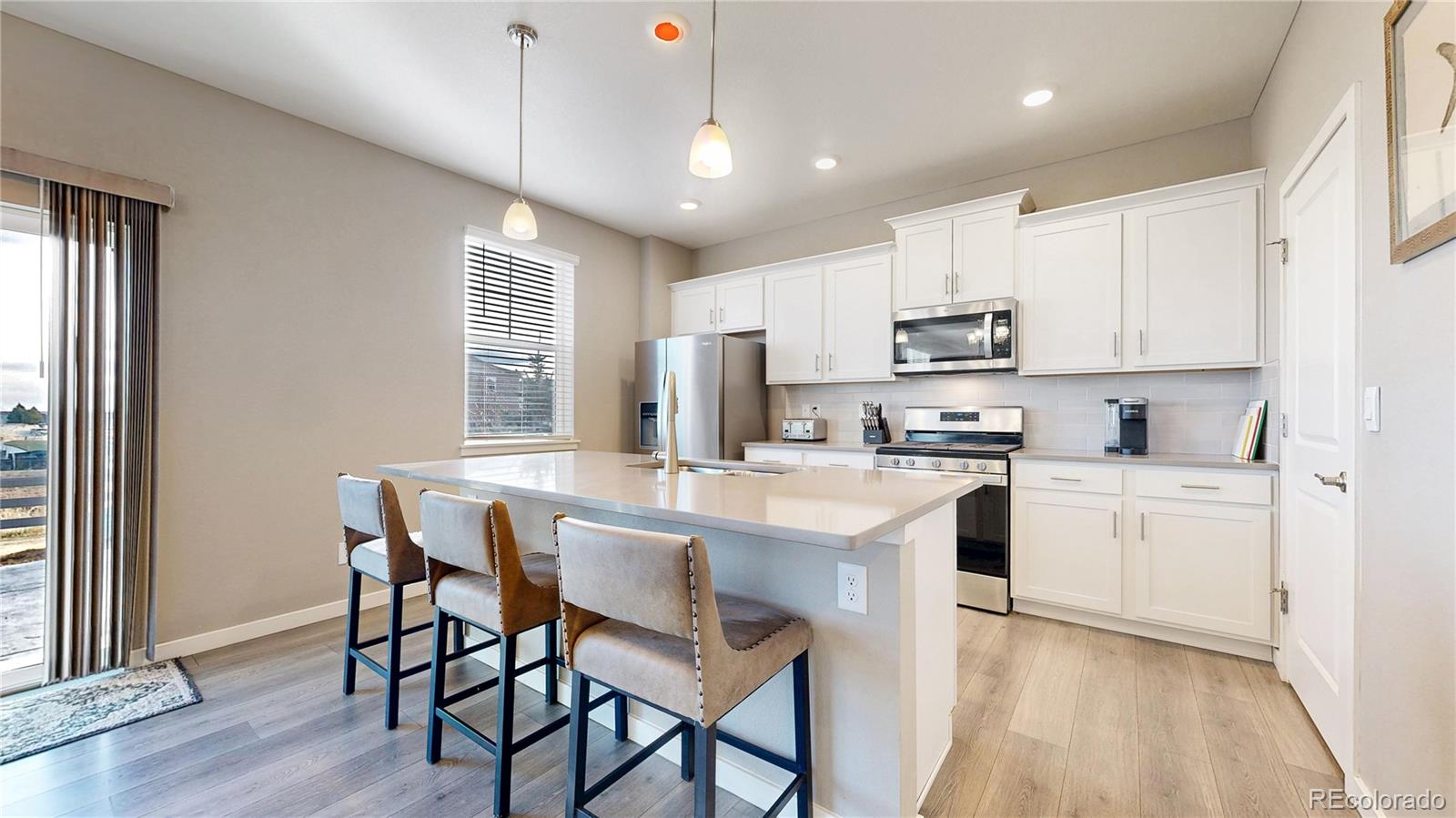1562 Sun River Road Berthoud, CO 80513 - Photo 11 of 46 a kitchen with kitchen island granite countertop a sink a center island and cabinets