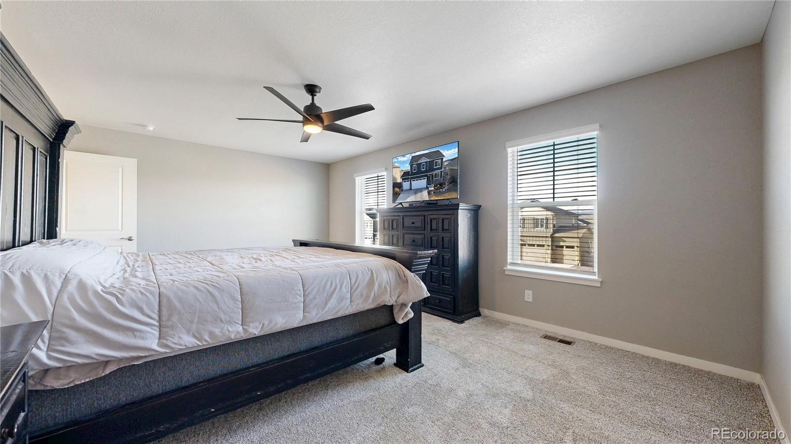 1562 Sun River Road Berthoud, CO 80513 - Photo 20 of 46 a spacious bedroom with a bed a chandelier and a window