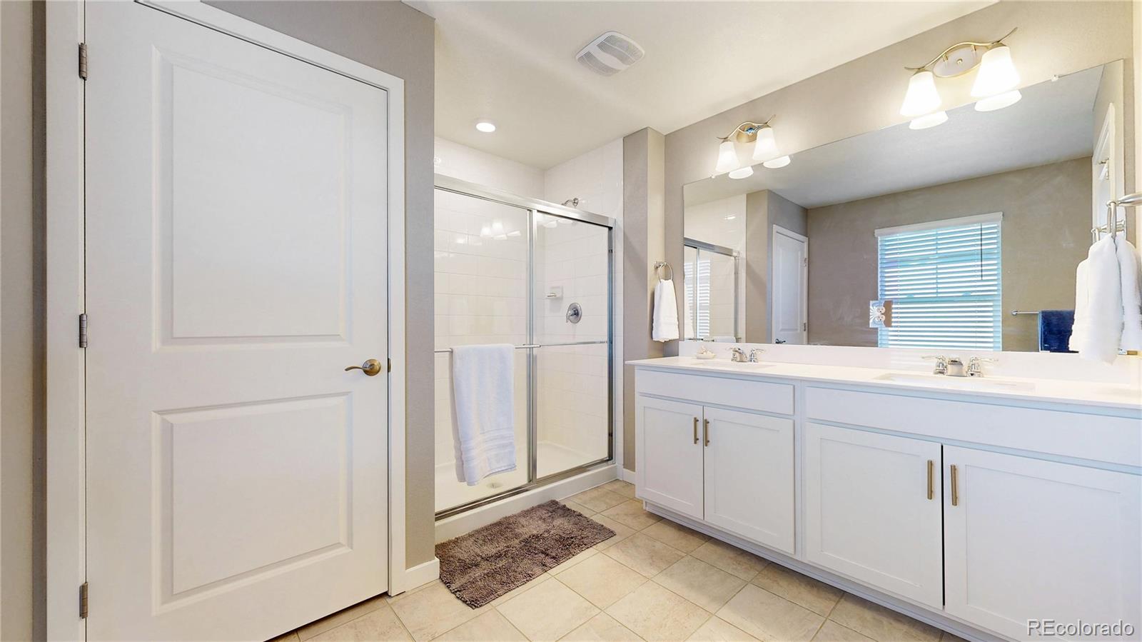 1562 Sun River Road Berthoud, CO 80513 - Photo 21 of 46 a bathroom with a double vanity sink and mirror