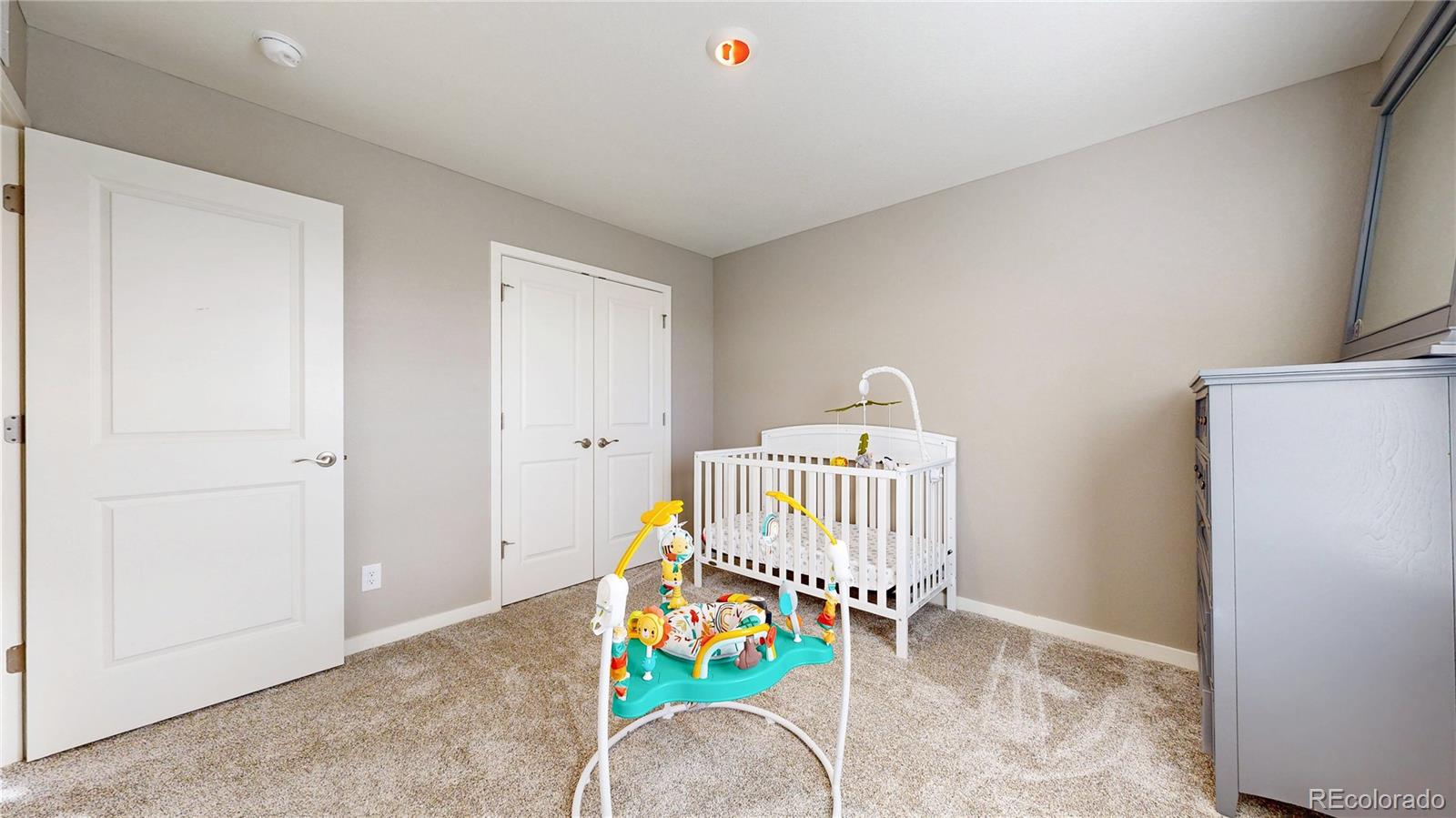 1562 Sun River Road Berthoud, CO 80513 - Photo 24 of 46 a living room with a baby crib furniture and a wooden floor