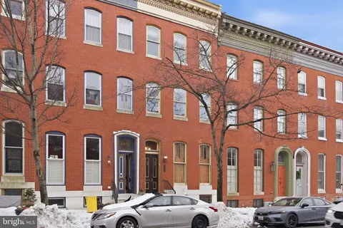 a front view of a building with lot of cars parked on road