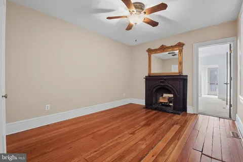 a view of empty room with wooden floor and fireplace