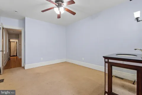 an empty room with closet and a chandelier fan
