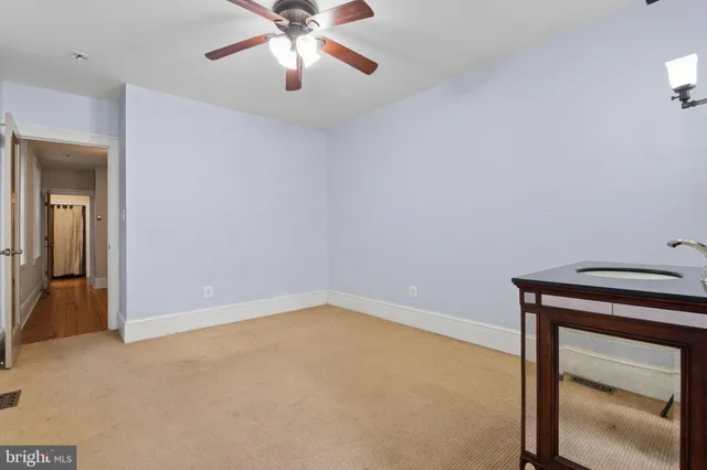 an empty room with closet and a chandelier fan