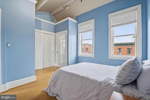 a bedroom with a bed and wooden floor