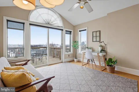 a living room with furniture a floor to ceiling window and a table
