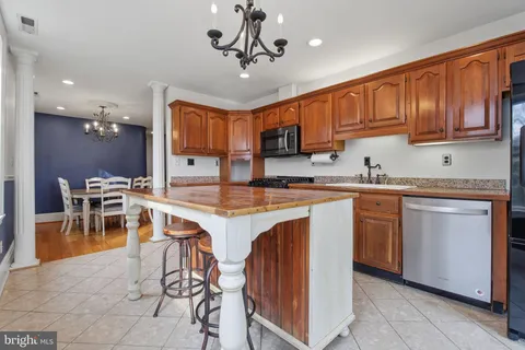 a kitchen with cabinets a sink stainless steel appliances and dining table
