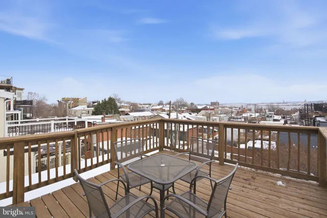 a view of a balcony with wooden chairs