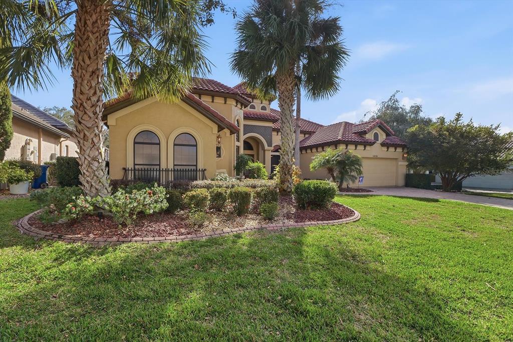 1416 North Ridge Meadow Path Hernando, FL 34442 - Photo 4 of 68 a front view of a house with a garden