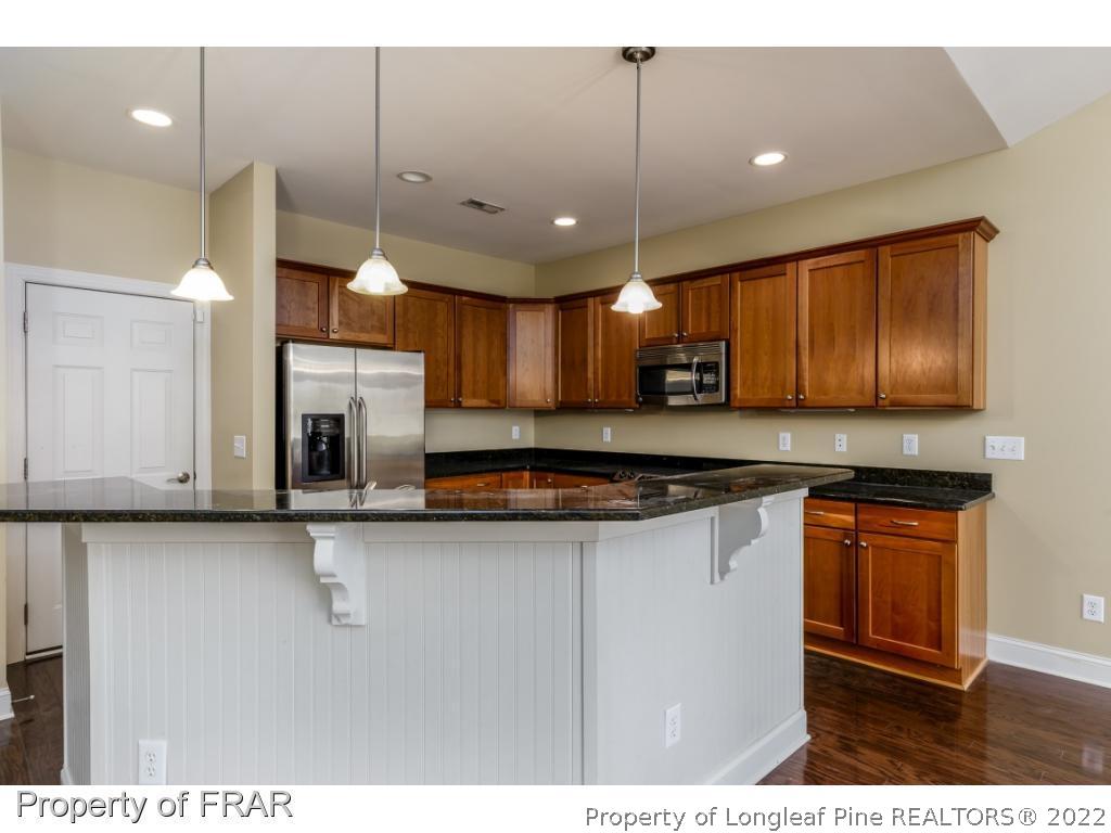 18 Elk Ridge Lane Southern Pines, NC 28387 - Photo 5 of 21 a kitchen with stainless steel appliances granite countertop a sink a stove a refrigerator and a microwave