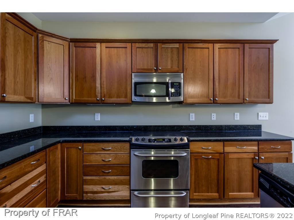 18 Elk Ridge Lane Southern Pines, NC 28387 - Photo 7 of 21 a kitchen with stainless steel appliances granite countertop a stove a microwave and cabinets