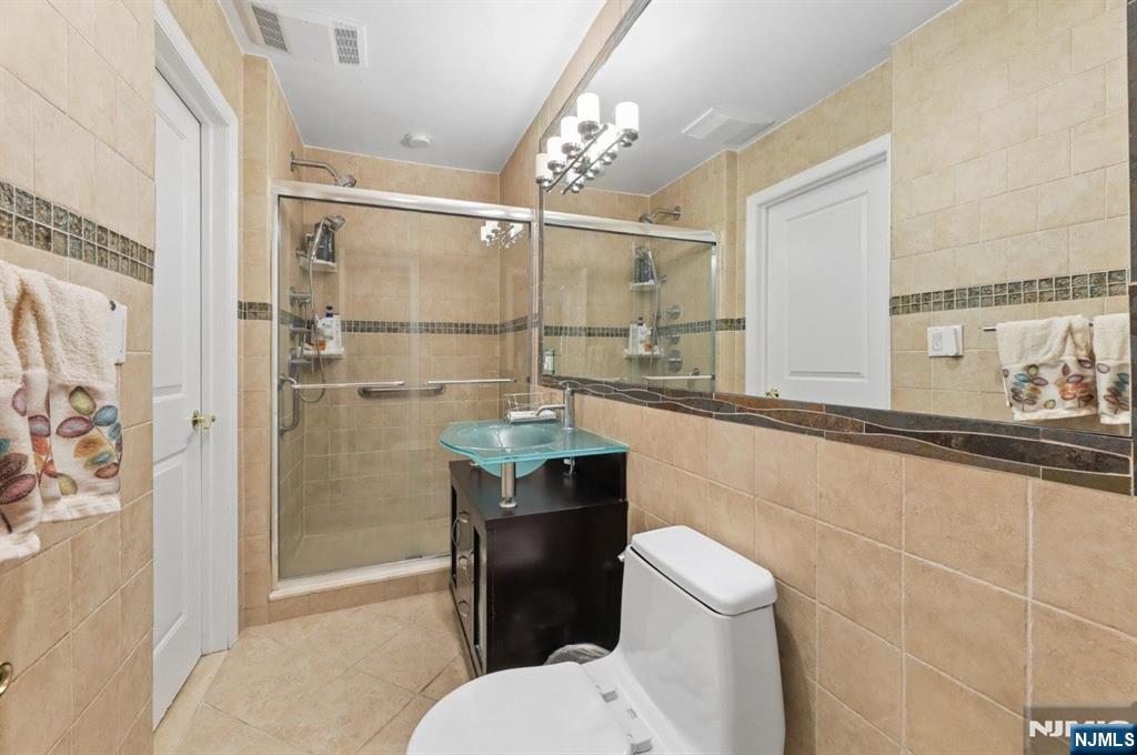 604 Rutland Avenue Teaneck, NJ 07666 - Photo 13 of 31 a bathroom with a granite countertop sink mirror toilet and shower