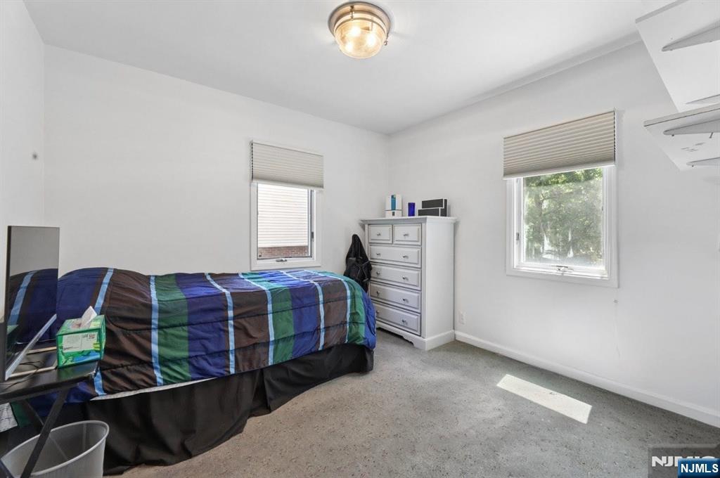 604 Rutland Avenue Teaneck, NJ 07666 - Photo 17 of 31 a bedroom with a bed and a chandelier
