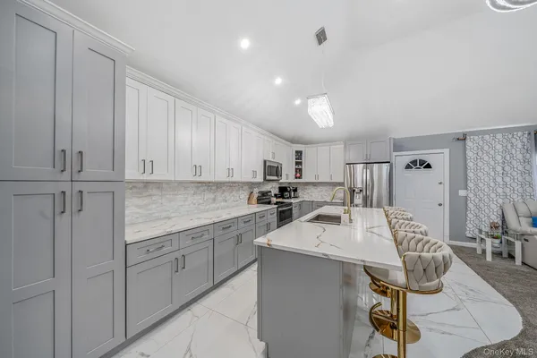 a kitchen with a sink chairs and cabinets