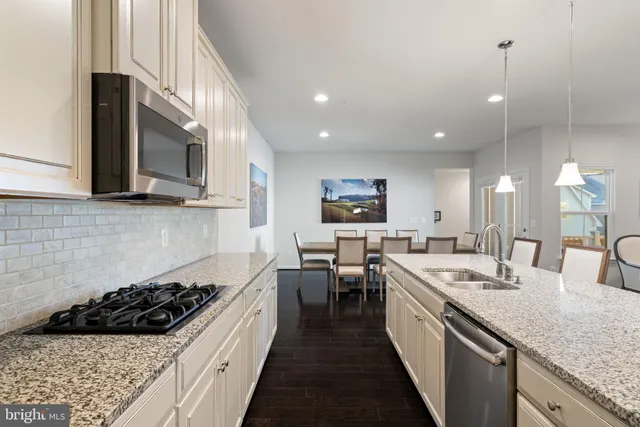 a living room with furniture white walls and kitchen view