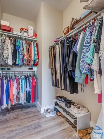 a view of walk in closet with clothes and shoes