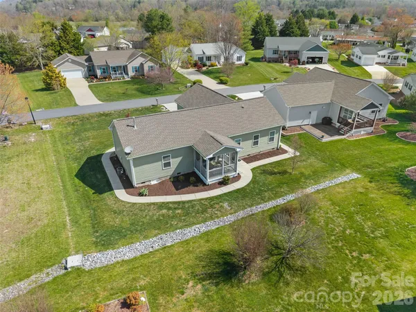 an aerial view of residential houses with outdoor space and swimming pool