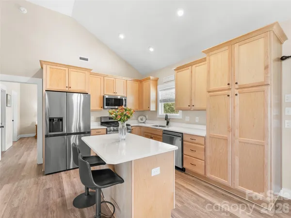 a kitchen with kitchen island white cabinets and stainless steel appliances