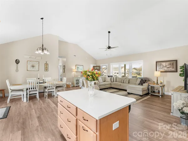a view of a dining room and livingroom with furniture wooden floor a chandelier