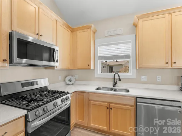 a kitchen with stainless steel appliances granite countertop a sink stove top oven and cabinets