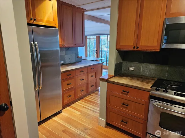 a kitchen with stainless steel appliances granite countertop a refrigerator and a stove top oven