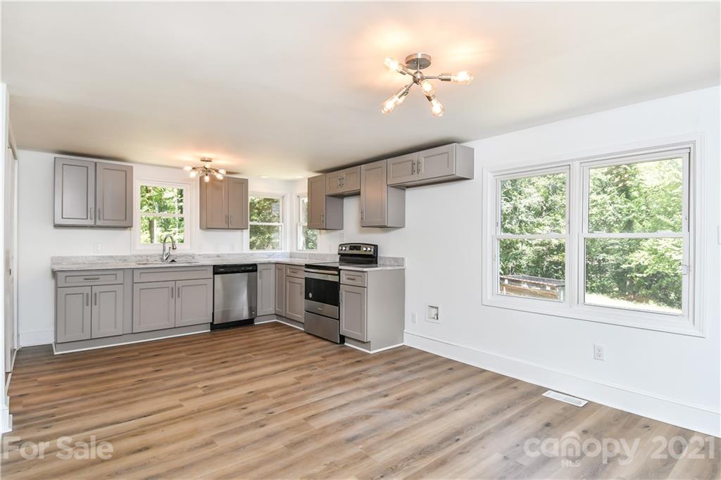 1215 Summerville Road Charlotte, NC 28214 - Photo 18 of 25 a kitchen with granite countertop a stove a sink dishwasher and a refrigerator with wooden floor