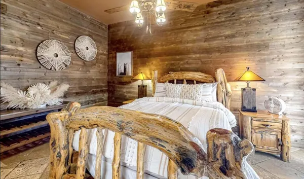 a bed sitting in a bedroom next to a lamp