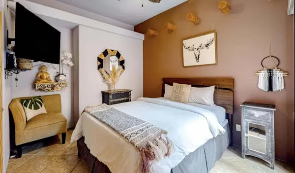 a bedroom with a bed and a flat screen tv