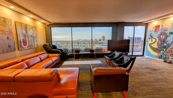 a living room with furniture a floor to ceiling window and a flat screen tv
