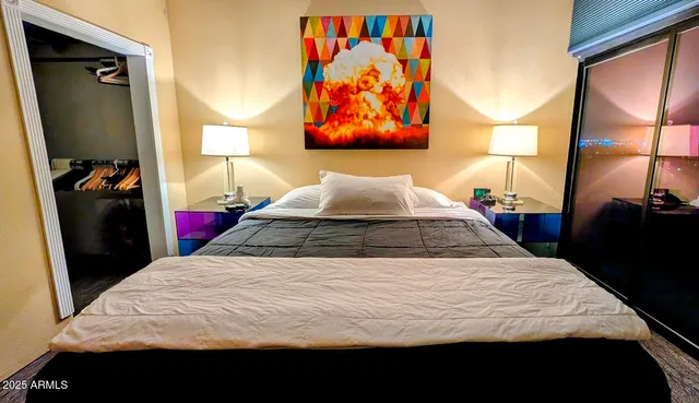 a bedroom with a bed and painting on the wall