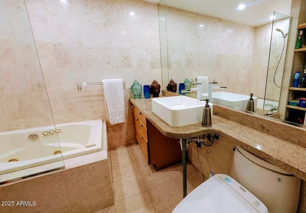 a bathroom with a tub a sink and a mirror