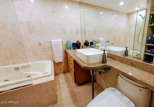 a bathroom with a tub a sink and a mirror