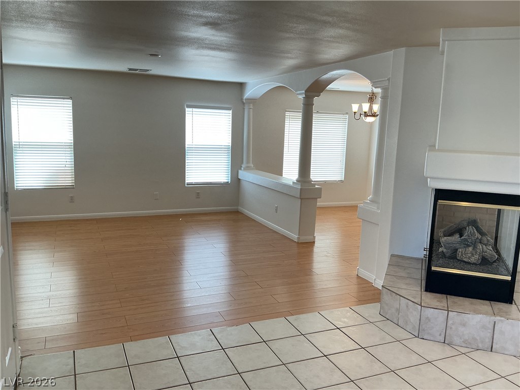 10975 Calcedonian Street Las Vegas, NV 89141 - Photo 8 of 25 This bright living space features elegant flooring and a cozy fireplace, perfect for gatherings.