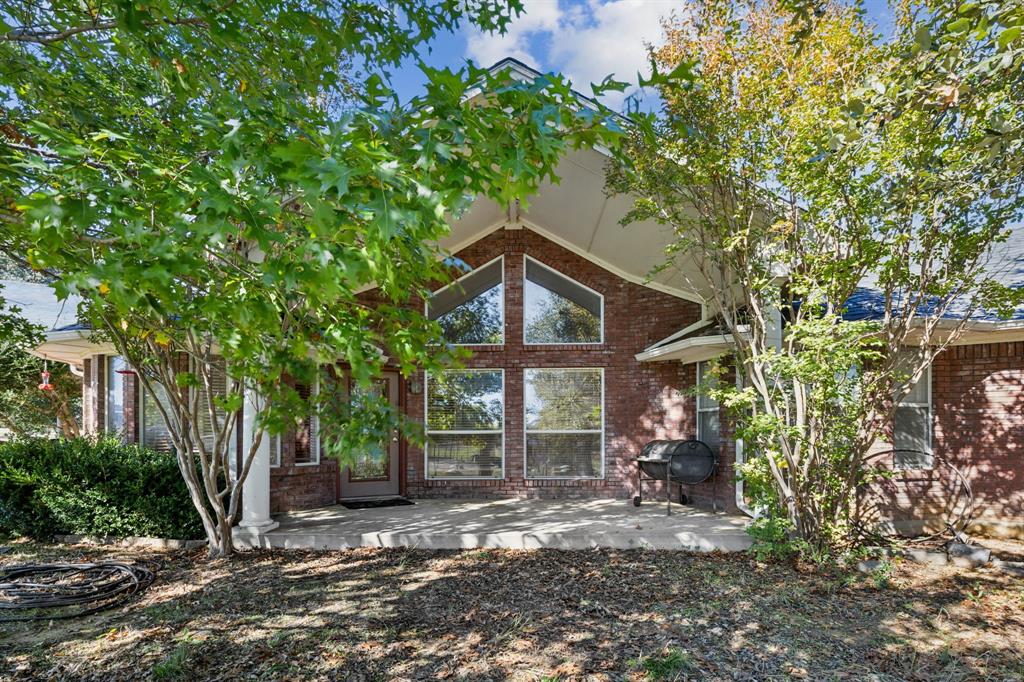 2212 Spring Hill Road Aubrey, TX 76227 - Photo 18 of 36 a view of a house with a tree and wooden fence