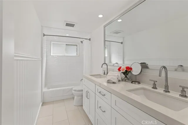 a bathroom with a double vanity sink mirror and toilet