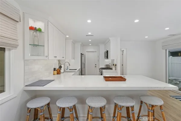a kitchen with stainless steel appliances a table and chairs in it